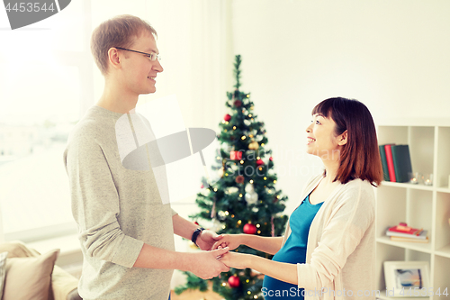 Image of pregnant wife with husband at home at christmas