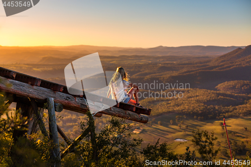 Image of Female relaxing at Mt Blackheath watching the golden sunlight from wooden platform