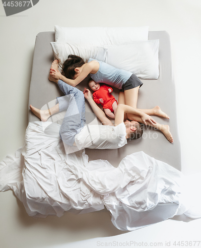 Image of Top view of happy family with one newborn child in bedroom.