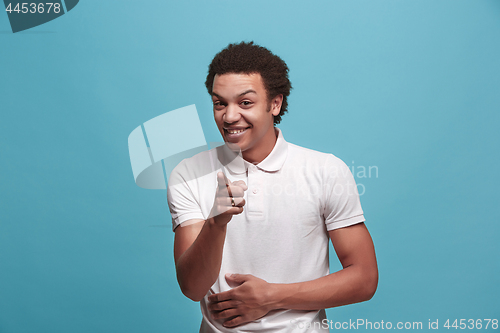 Image of The happy business man point you and want you, half length closeup portrait on blue background.