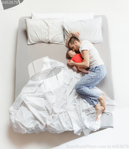 Image of Top view of happy family with one newborn child in bedroom.