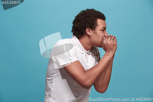 Image of Isolated on blue young casual man shouting at studio