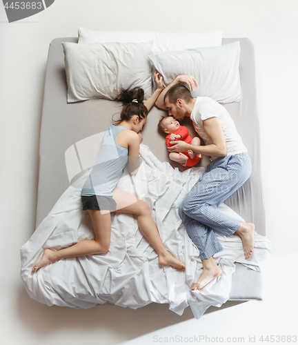 Image of Top view of happy family with one newborn child in bedroom.