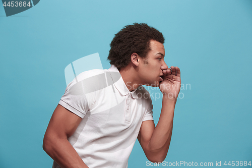 Image of Isolated on blue young casual man shouting at studio