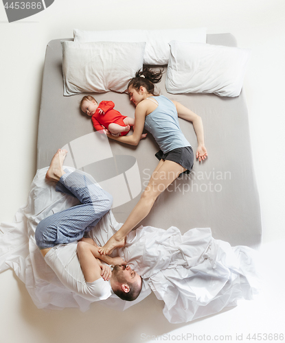 Image of Top view of happy family with one newborn child in bedroom.