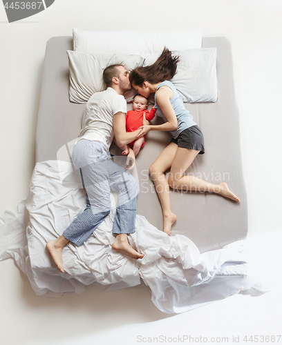 Image of Top view of happy family with one newborn child in bedroom.