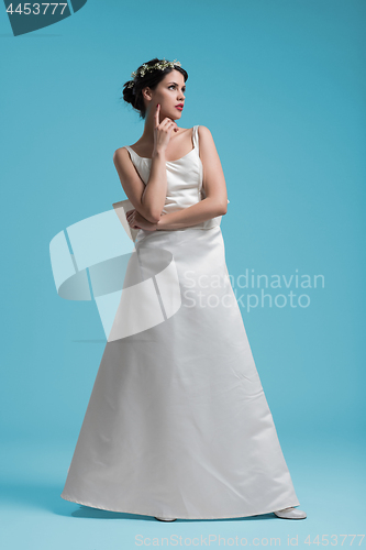 Image of beautiful woman wearing wedding dress against cyan background