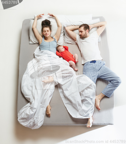 Image of Top view of happy family with one newborn child in bedroom.