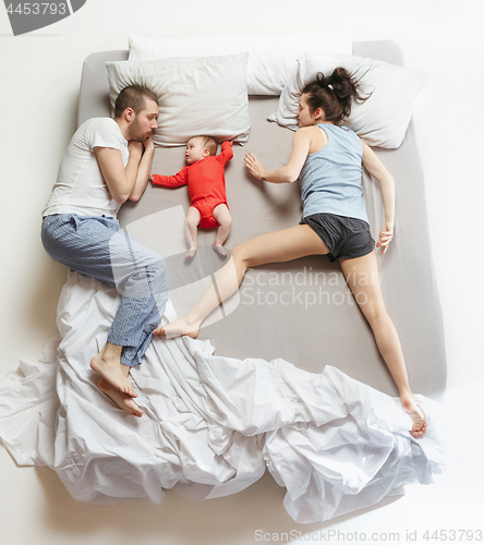 Image of Top view of happy family with one newborn child in bedroom.