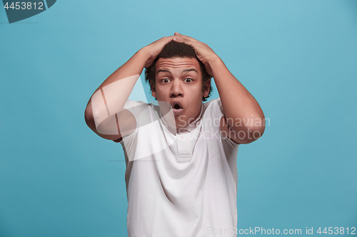 Image of The young attractive man looking suprised isolated on pink