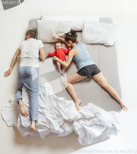 Image of Top view of happy family with one newborn child in bedroom.