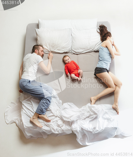 Image of Top view of happy family with one newborn child in bedroom.