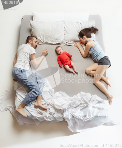 Image of Top view of happy family with one newborn child in bedroom.