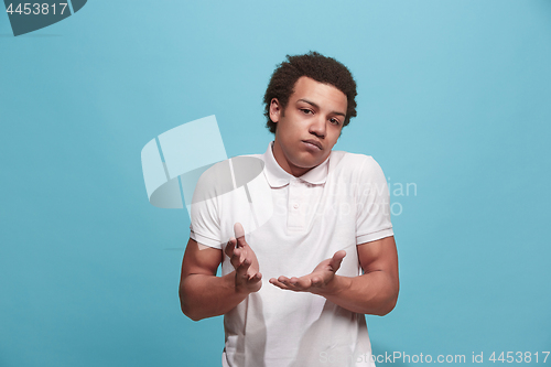 Image of Let me think. Doubtful pensive man with thoughtful expression making choice against blue background