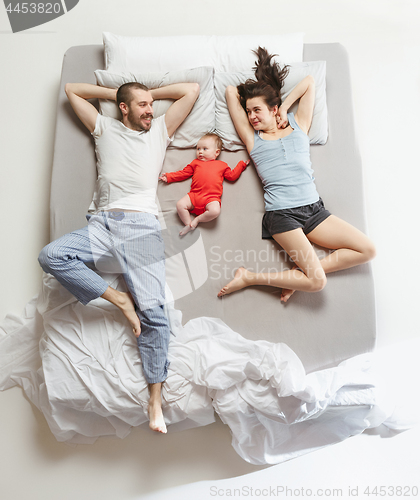 Image of Top view of happy family with one newborn child in bedroom.