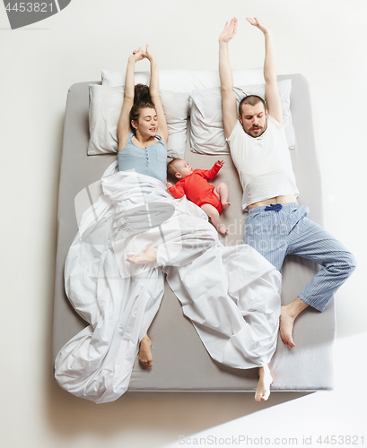 Image of Top view of happy family with one newborn child in bedroom.