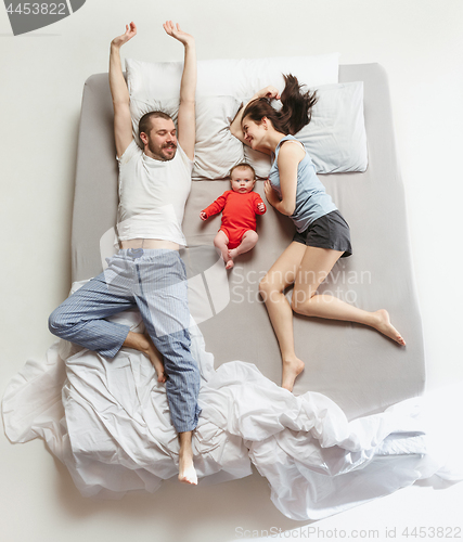 Image of Top view of happy family with one newborn child in bedroom.