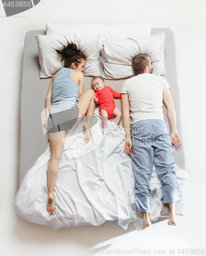 Image of Top view of happy family with one newborn child in bedroom.