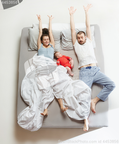 Image of Top view of happy family with one newborn child in bedroom.