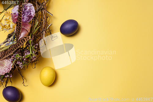 Image of Easter card. Painted Easter eggs in nest on yellow background