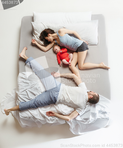 Image of Top view of happy family with one newborn child in bedroom.