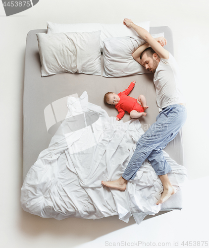 Image of Top view of happy family with one newborn child in bedroom.