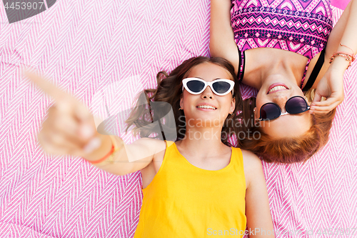 Image of teenage girls in sunglasses on picnic blanket