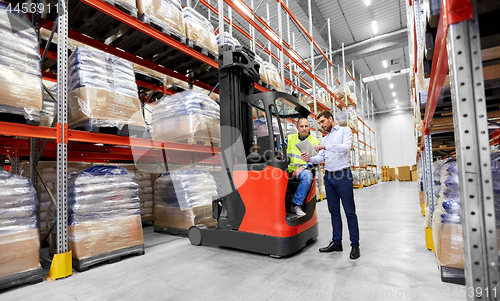 Image of worker and businessman with tablet pc at warehouse