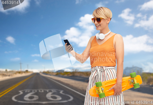 Image of teenage girl with skateboard and smartphone