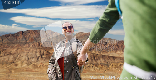 Image of happy couple with backpacks hiking outdoors