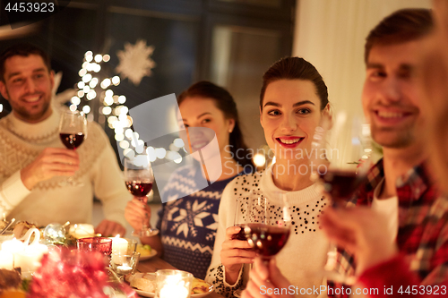 Image of happy friends celebrating christmas at home