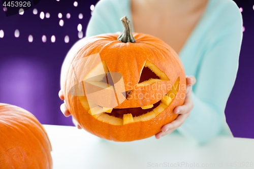 Image of close up of woman with halloween pumpkin