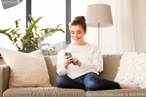 Image of woman with smartphone at home