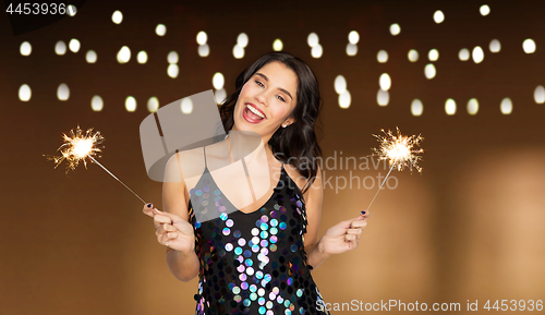 Image of happy young woman with sparklers at party