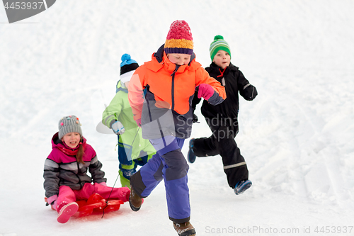 Image of happy kids with sled having fun outdoors in winter