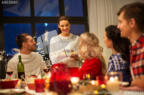 Image of happy friends having christmas dinner at home