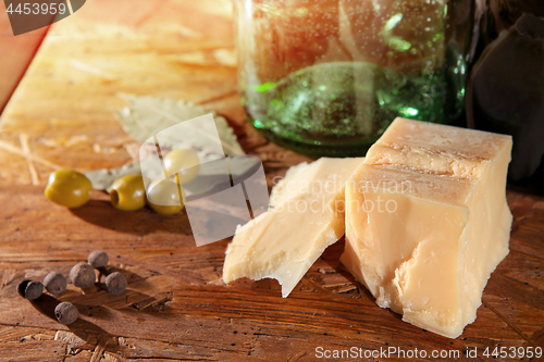 Image of parmesan and olives on wooden surface 