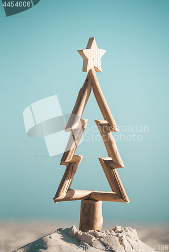 Image of Rustic timber driftwood Christmas tree in sand by the beach