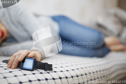 Image of Woman sleeping with smartwatch 