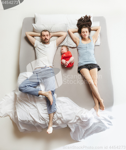 Image of Top view of happy family with one newborn child in bedroom.