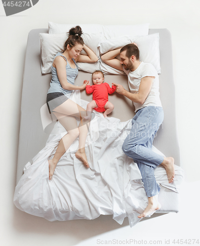 Image of Top view of happy family with one newborn child in bedroom.