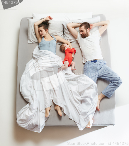 Image of Top view of happy family with one newborn child in bedroom.