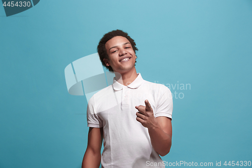 Image of The happy business man point you and want you, half length closeup portrait on blue background.