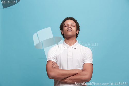 Image of Suspiciont. Doubtful pensive man with thoughtful expression making choice against blue background