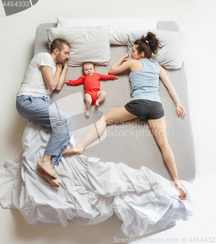 Image of Top view of happy family with one newborn child in bedroom.