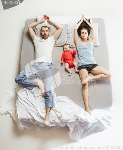 Image of Top view of happy family with one newborn child in bedroom.