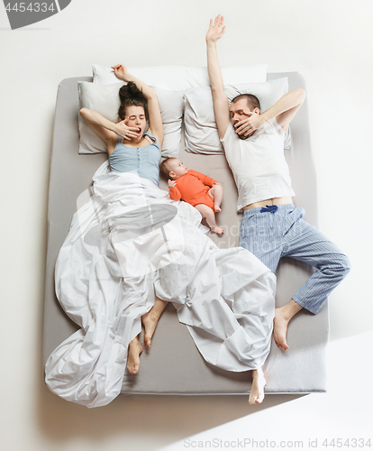 Image of Top view of happy family with one newborn child in bedroom.