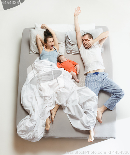 Image of Top view of happy family with one newborn child in bedroom.