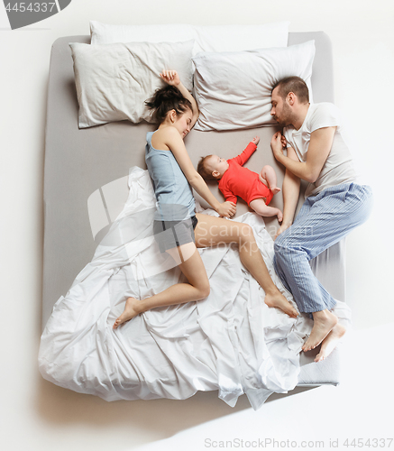 Image of Top view of happy family with one newborn child in bedroom.