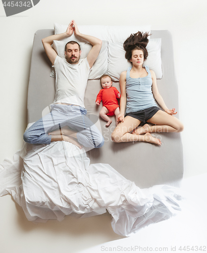 Image of Top view of happy family with one newborn child in bedroom.